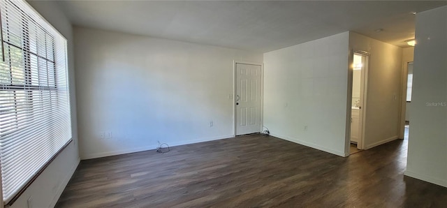 empty room with dark wood finished floors and baseboards