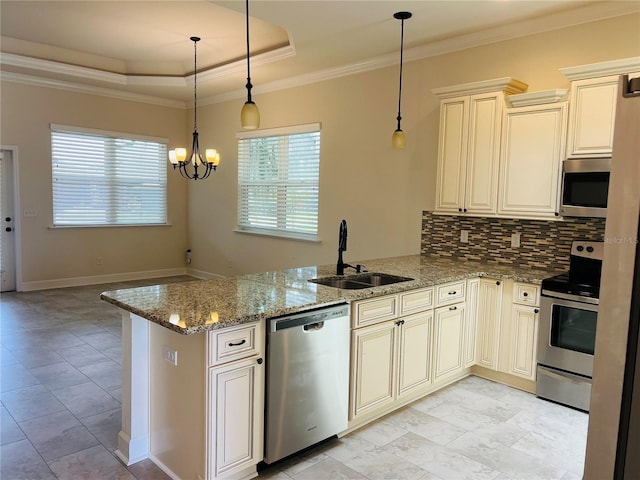 kitchen with light stone counters, a peninsula, cream cabinets, stainless steel appliances, and a sink