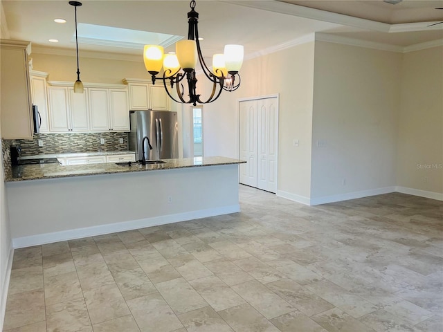 kitchen with stone counters, decorative light fixtures, crown molding, stainless steel appliances, and a sink