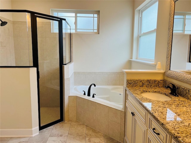 full bathroom featuring a wealth of natural light, a garden tub, and vanity