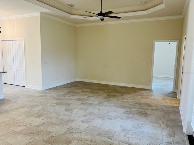 unfurnished room with a ceiling fan, a raised ceiling, crown molding, and baseboards