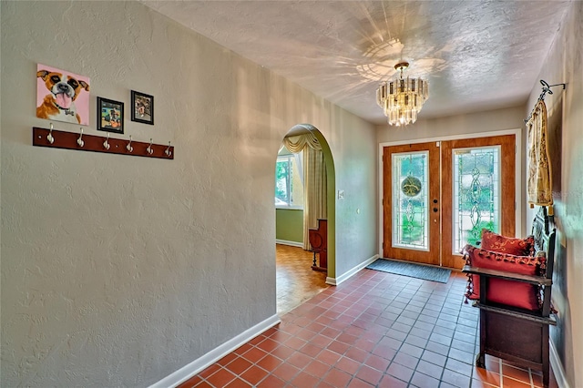 entrance foyer featuring french doors, a textured ceiling, and tile patterned floors