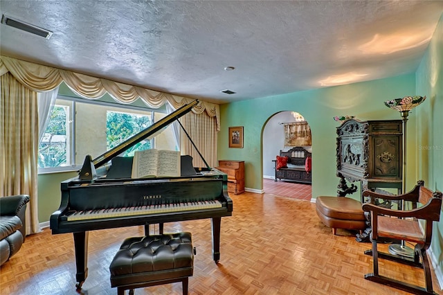 miscellaneous room featuring a textured ceiling and parquet flooring