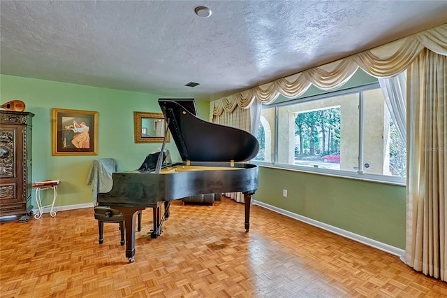 misc room featuring a textured ceiling and light parquet flooring