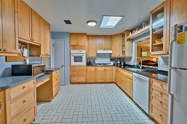 kitchen featuring white appliances, light brown cabinetry, tasteful backsplash, and sink