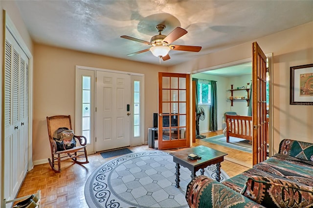 foyer with ceiling fan and light parquet flooring