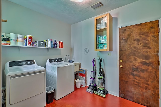 laundry room with a textured ceiling, sink, and washer and dryer