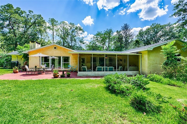 back of property featuring a sunroom, a patio, central AC unit, and a lawn