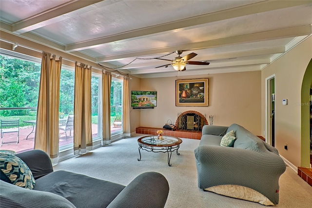 carpeted living room with ceiling fan and beam ceiling