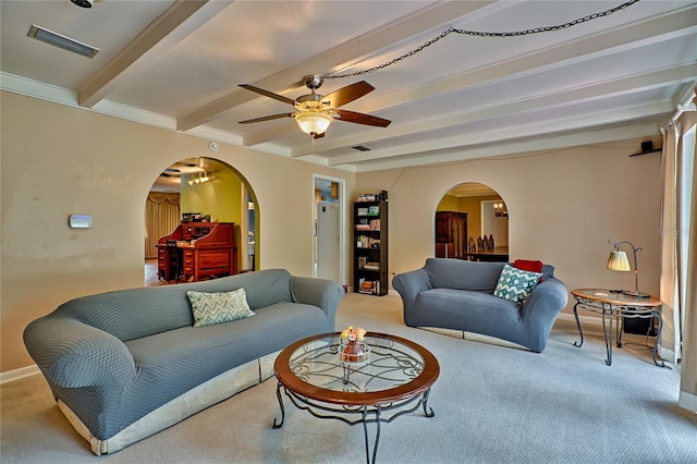 living room featuring ceiling fan, beamed ceiling, and carpet