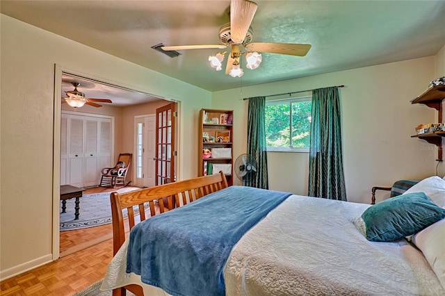 bedroom featuring ceiling fan, a closet, and parquet flooring