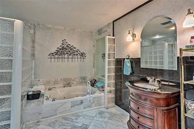 4700 NW 19th Pl, Gainesville, FL 32605 - full bathroom with tile walls, a jetted tub, marble finish floor, and vanity