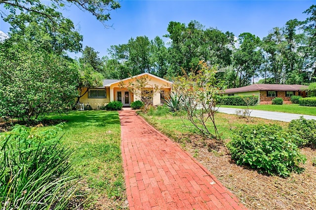 4700 NW 19th Pl, Gainesville, FL 32605 - view of front of property featuring french doors, a front yard, and stucco siding