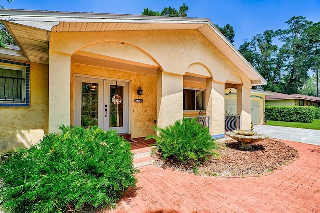 4700 NW 19th Pl, Gainesville, FL 32605 - view of exterior entry featuring covered porch, driveway, and stucco siding