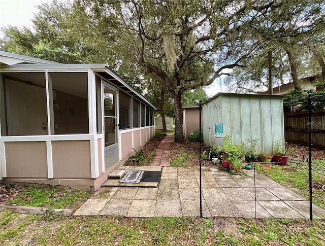 view of patio with a storage shed and a sunroom