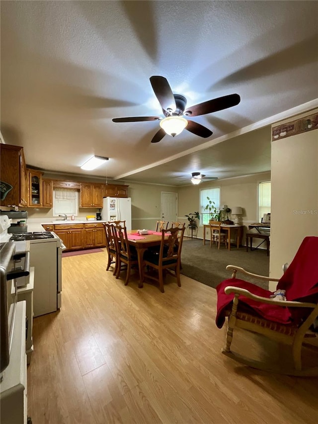 carpeted dining area featuring ceiling fan and sink