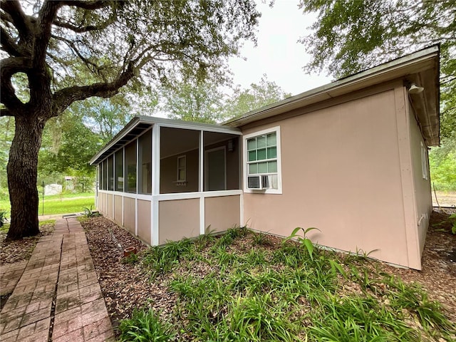 view of home's exterior with a sunroom and cooling unit