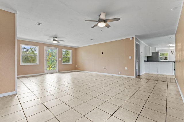 unfurnished living room with ornamental molding, a healthy amount of sunlight, light tile patterned flooring, and ceiling fan