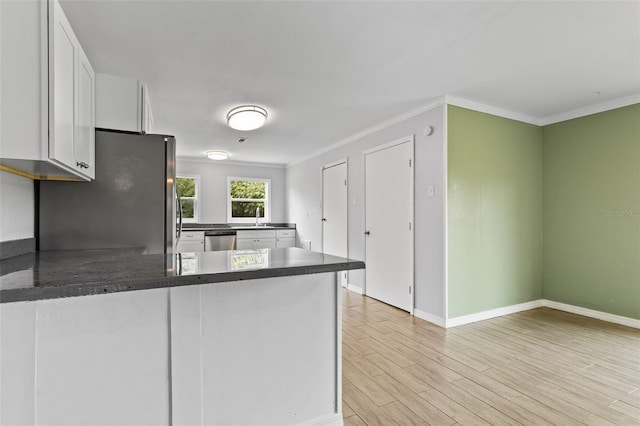 kitchen with white cabinets, light wood-type flooring, stainless steel appliances, sink, and kitchen peninsula