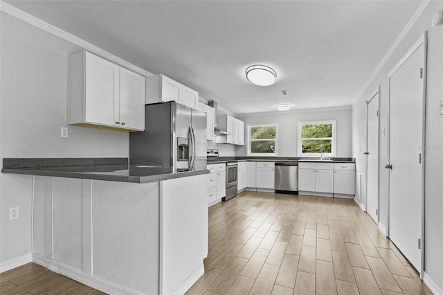 kitchen with white cabinets, stainless steel appliances, light hardwood / wood-style floors, sink, and kitchen peninsula