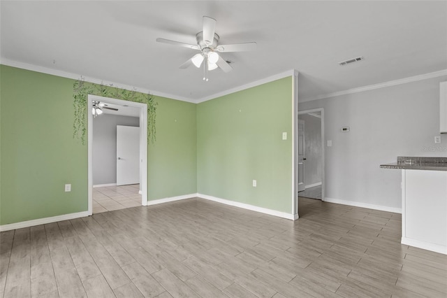 spare room featuring light wood-type flooring, ceiling fan, and crown molding