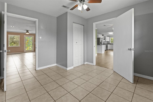 tiled spare room with ceiling fan