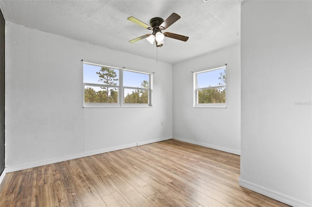 empty room with light wood-type flooring, a textured ceiling, and ceiling fan