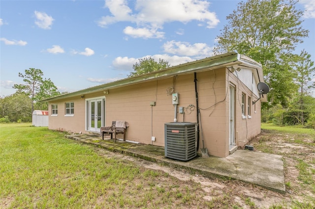 rear view of house featuring a lawn, a patio area, and cooling unit