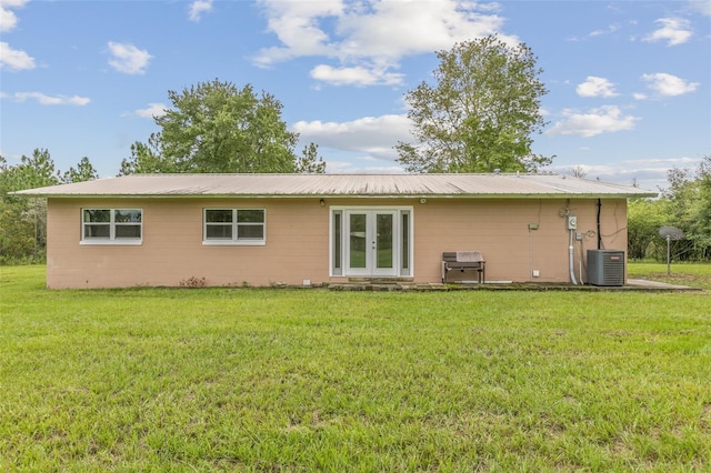 rear view of house featuring a yard and cooling unit