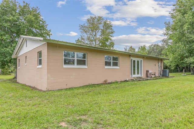 exterior space with central AC and a yard