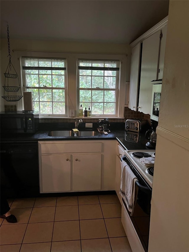 kitchen with black appliances, sink, plenty of natural light, and white cabinetry