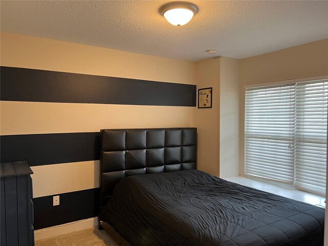 bedroom with carpet and a textured ceiling