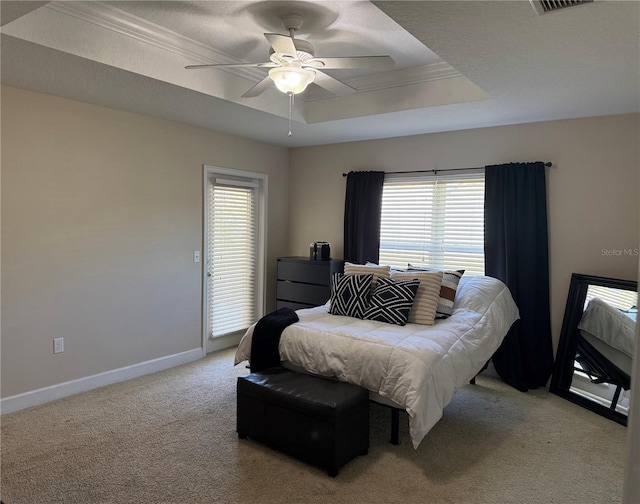 bedroom featuring a tray ceiling, visible vents, a ceiling fan, light carpet, and baseboards