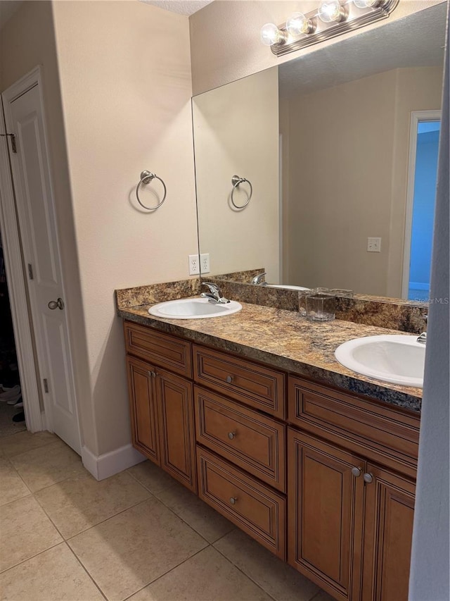 full bathroom featuring tile patterned flooring, a sink, and double vanity