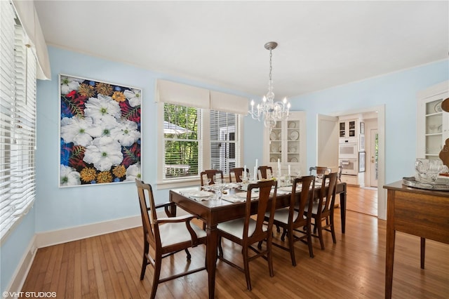 dining room with a notable chandelier and wood-type flooring