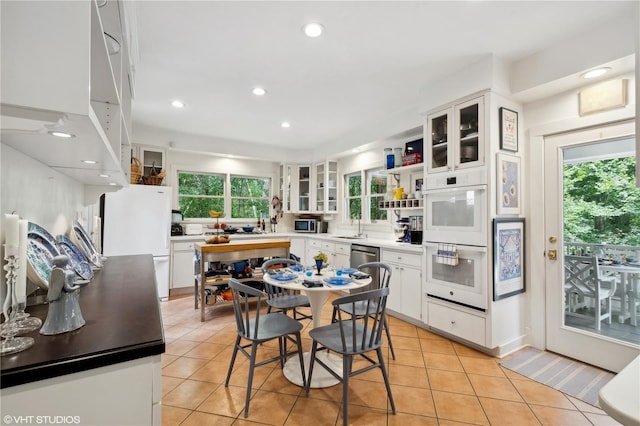 kitchen featuring white cabinetry, sink, light tile patterned floors, and white appliances