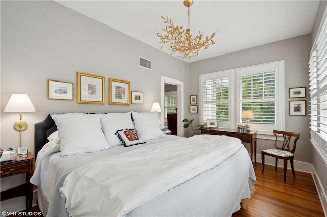 bedroom with dark wood-type flooring and a chandelier