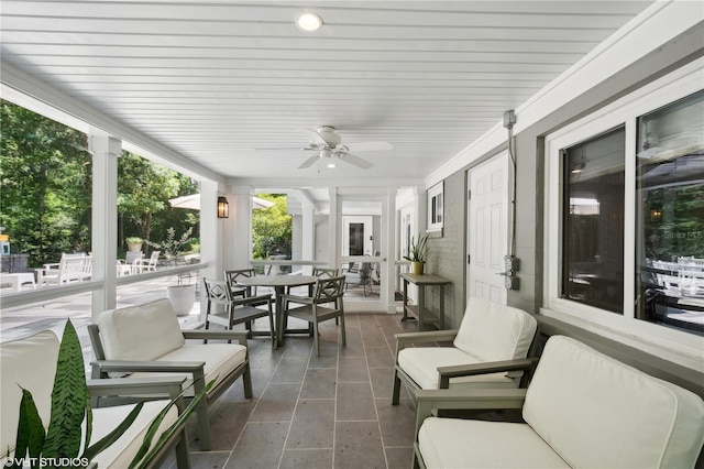 sunroom / solarium featuring ceiling fan