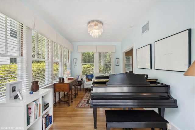 living area featuring a notable chandelier and light hardwood / wood-style floors