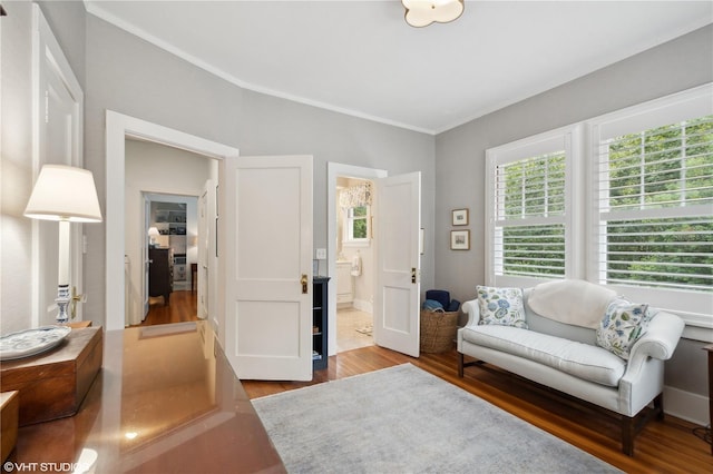 living area featuring crown molding, wood-type flooring, and a wealth of natural light