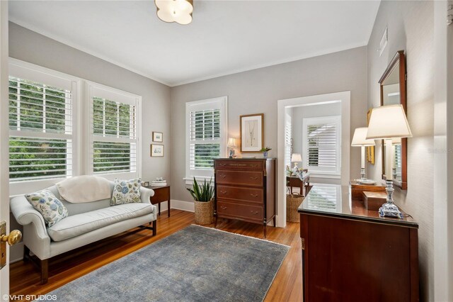 sitting room with ornamental molding and light hardwood / wood-style floors