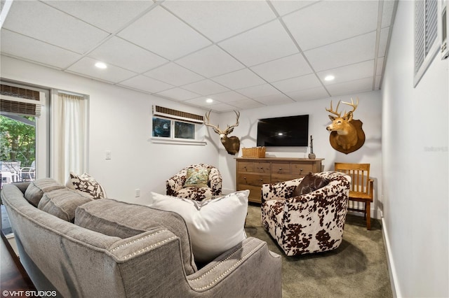 carpeted living room featuring a drop ceiling