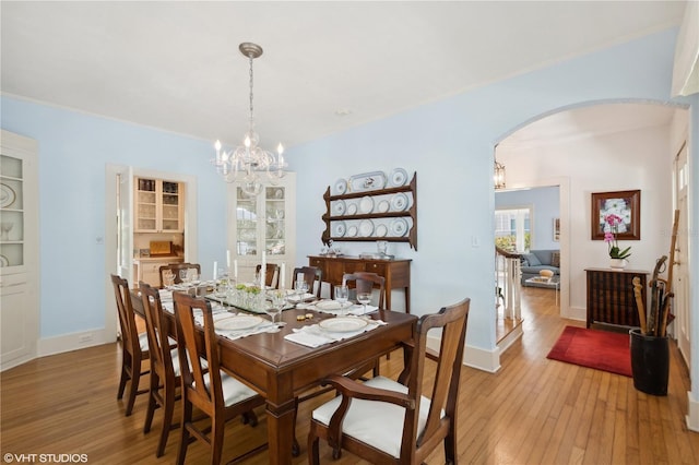 dining room with an inviting chandelier, crown molding, and light hardwood / wood-style floors