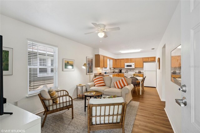 living room featuring ceiling fan and light hardwood / wood-style floors