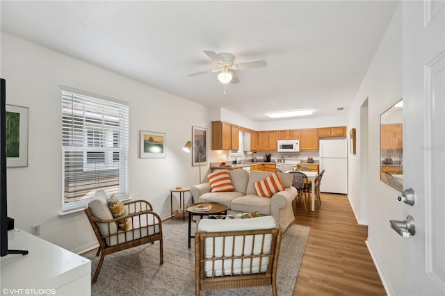 living room with ceiling fan and light hardwood / wood-style floors