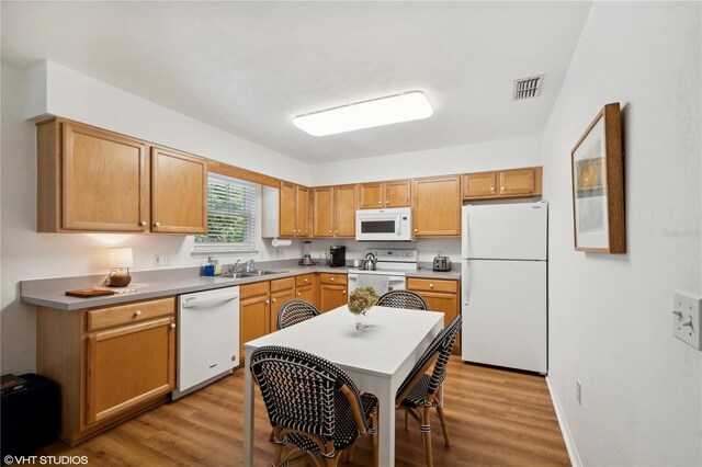 kitchen featuring white appliances, light hardwood / wood-style flooring, and sink