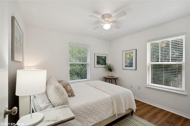 bedroom featuring multiple windows, hardwood / wood-style floors, and ceiling fan