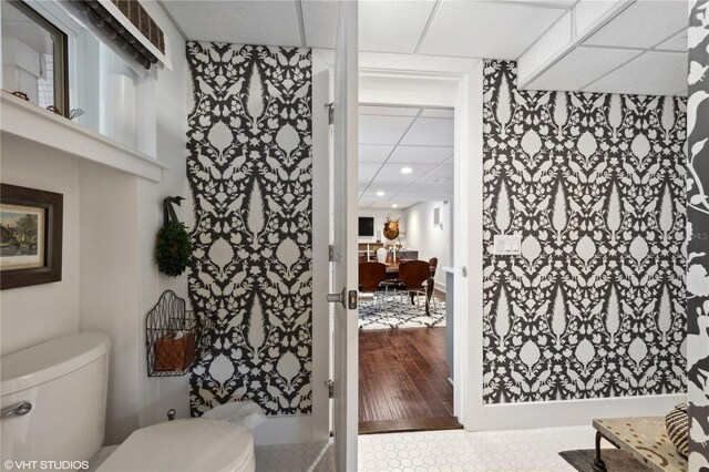 bathroom featuring a paneled ceiling, hardwood / wood-style flooring, vanity, and toilet