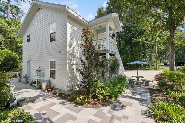 view of home's exterior with a patio and a balcony