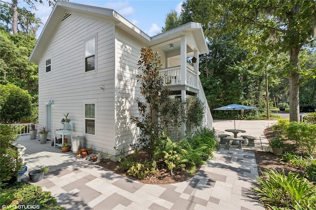 view of side of home with a balcony and a patio